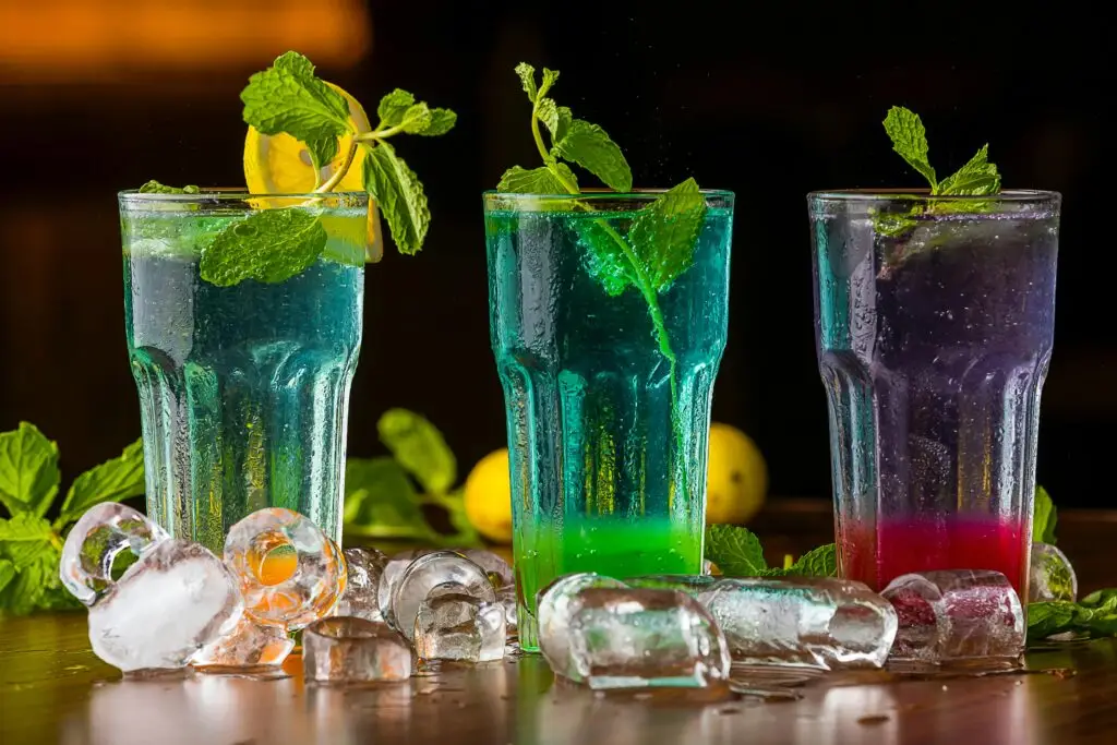Vibrant mocktails garnished with mint and ice cubes, perfect for a refreshing drink.