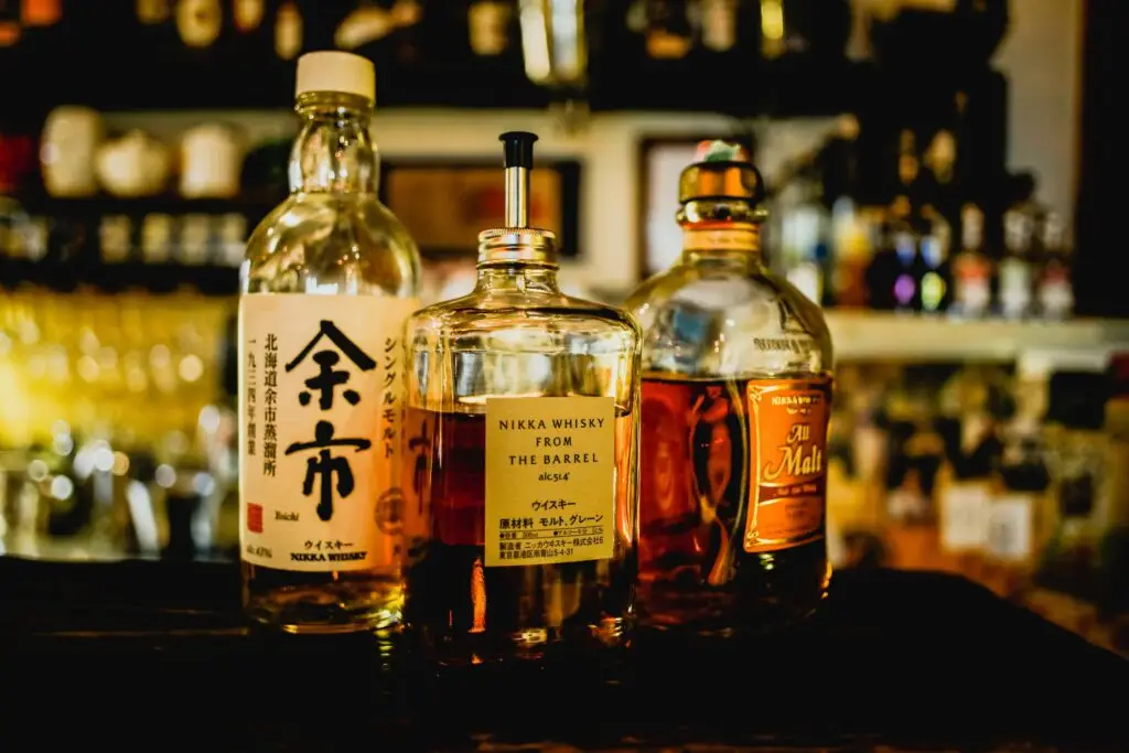 Selection of Japanese whisky bottles displayed in a dimly lit bar setting.